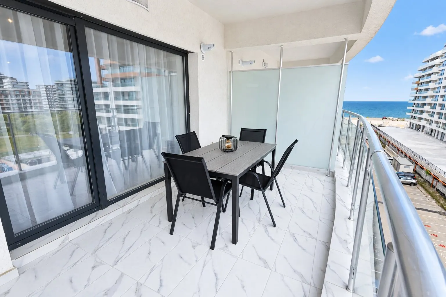 Balcon cu masă pentru patru și vedere spre mare și plajă, la Casa del Mar, Mamaia Nord