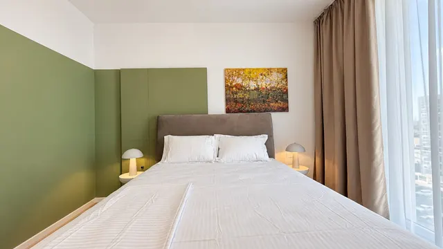 Dormitor cu perete verde, veioze și un tablou cu toamnă, la Torontal, Timișoara