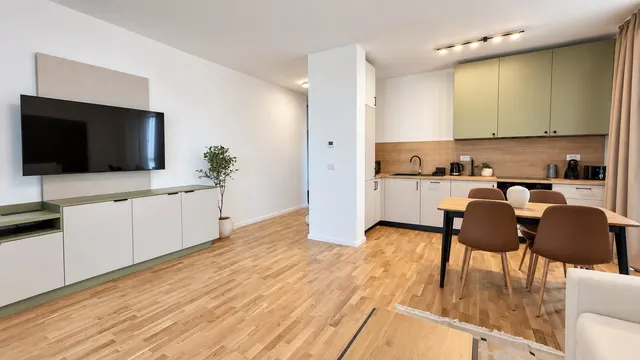 Living deschis spre bucătărie, cu televizor și fereastră mare, la Torontal, Timișoara