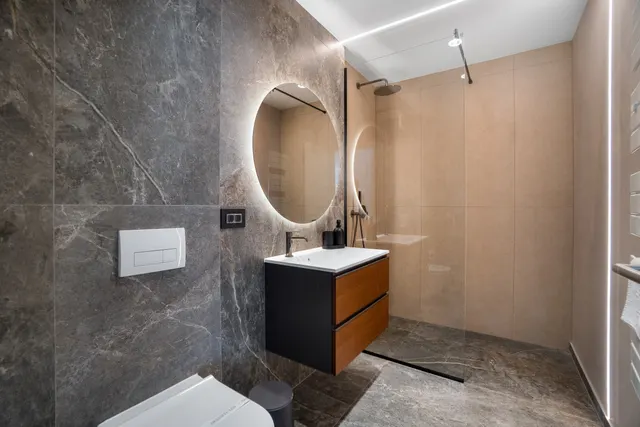 Baie cu duș walk-in, marmură gri și oglindă rotundă luminată, la Coresi, Brașov