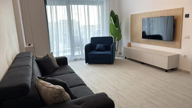 Living cu fotoliu albastru, canapea și ieșire pe balcon, la Casa del Mar, Mamaia Nord